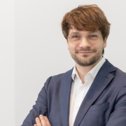 Portrait of Dr. Adrian Steffens smiling relaxedly at the camera with his arms crossed.