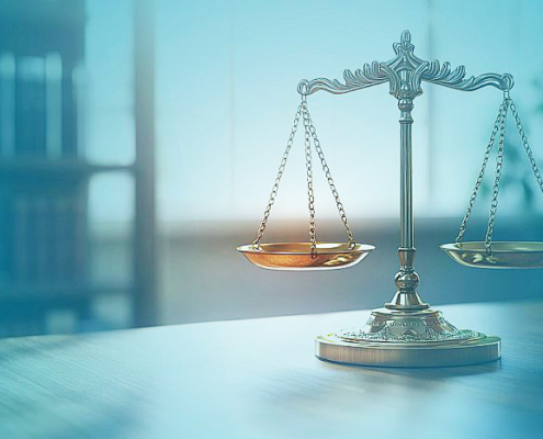 Goldene Balkenwaage auf Tisch, im Vorder- und Hintergrund blaue Farbverläufe; das Bild dient als Key Visual für den UPC-Update.